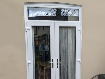 Removal of window and brickwork to create UPVC white French doors with toplight to give access to a Fleetwood garden.