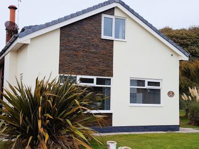 Rendering over brickwork and coated in Cotswald Cream wall coating with a slate infill detail for a Lytham St Annes home.